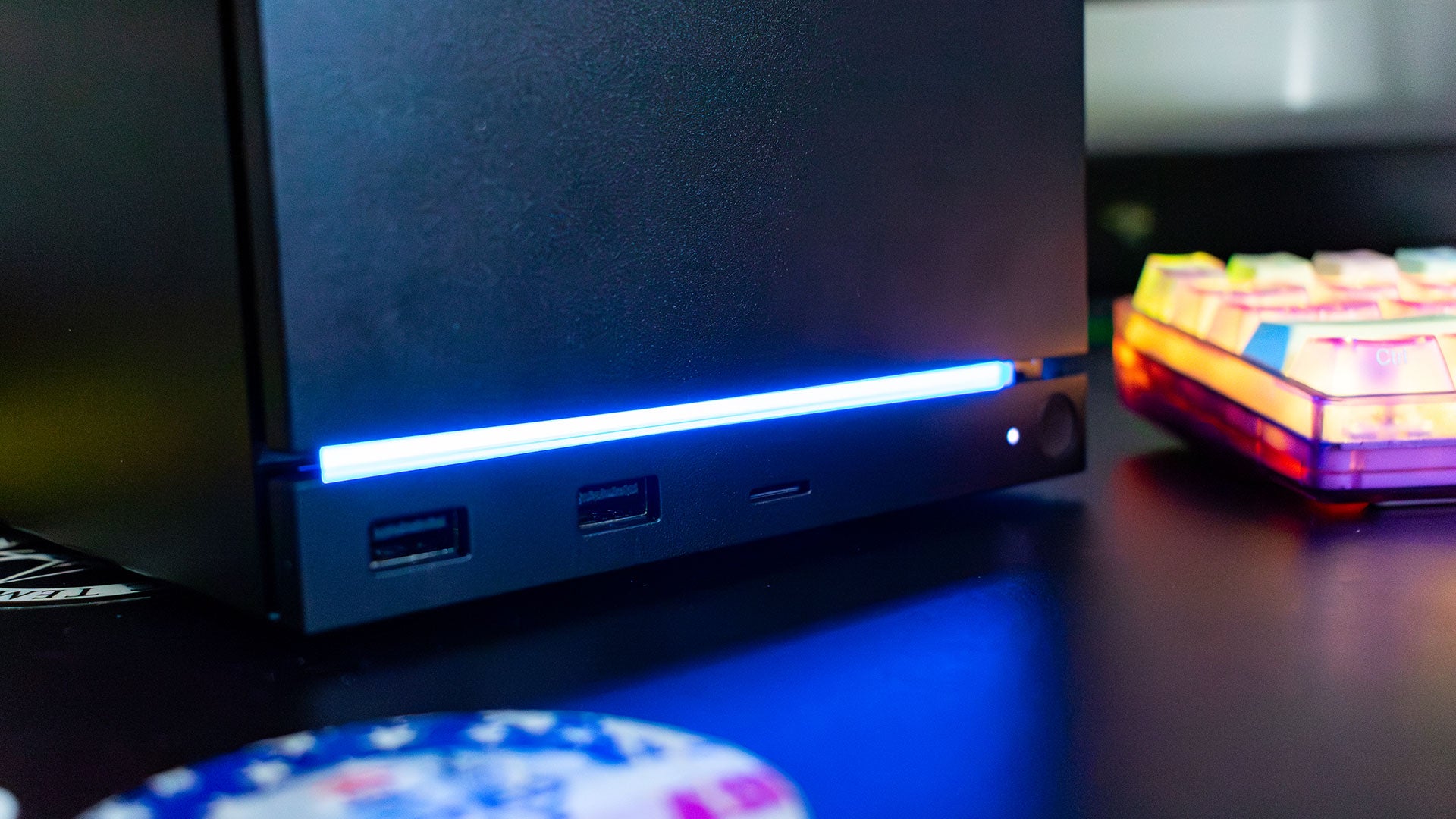 스팀 머신 전면 포트 클로즈업 — USB3-A 2개, microSD 슬롯, 파란 RGB 라이트 스트립